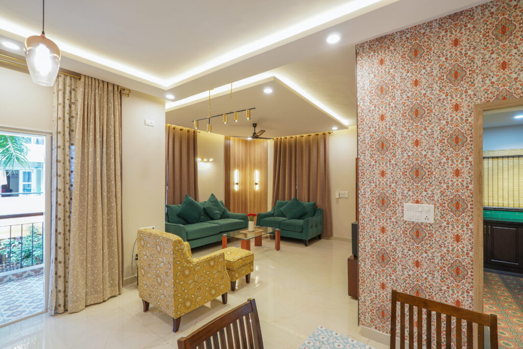 Bright living room with green sofas, a yellow patterned armchair, and a floral wallpaper accent wall.